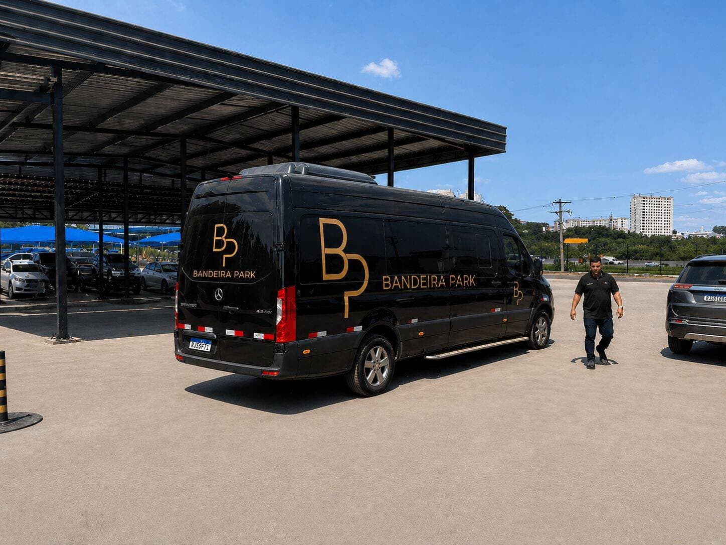Motorista ao lado da van Sprinter do Bandeira Park no pátio coberto de Guarulhos